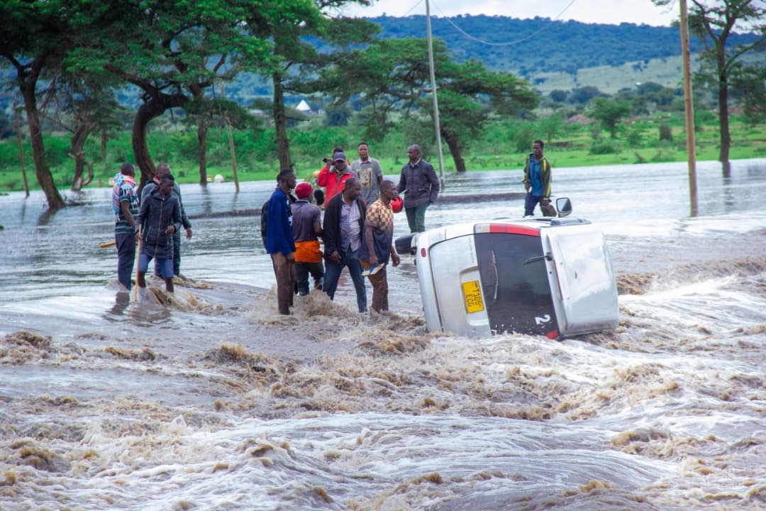 Residents of Nyichoka village in Serengeti District look on helplessly at the weekend as a car is swept away by floodwaters that left Rubana River Bridge submerged. 