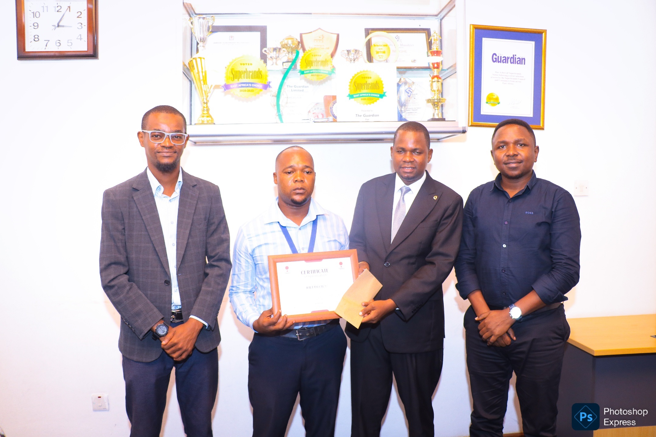 Tanzania Road Safety Initiative director Maliki Barongo (2nd-R) presents a certificate of recognition to Nipashe newspaper journalist Halfan Chusi in recognition of his outstanding reporting on road safety. The event was held at The Guardian Limited (TGL)