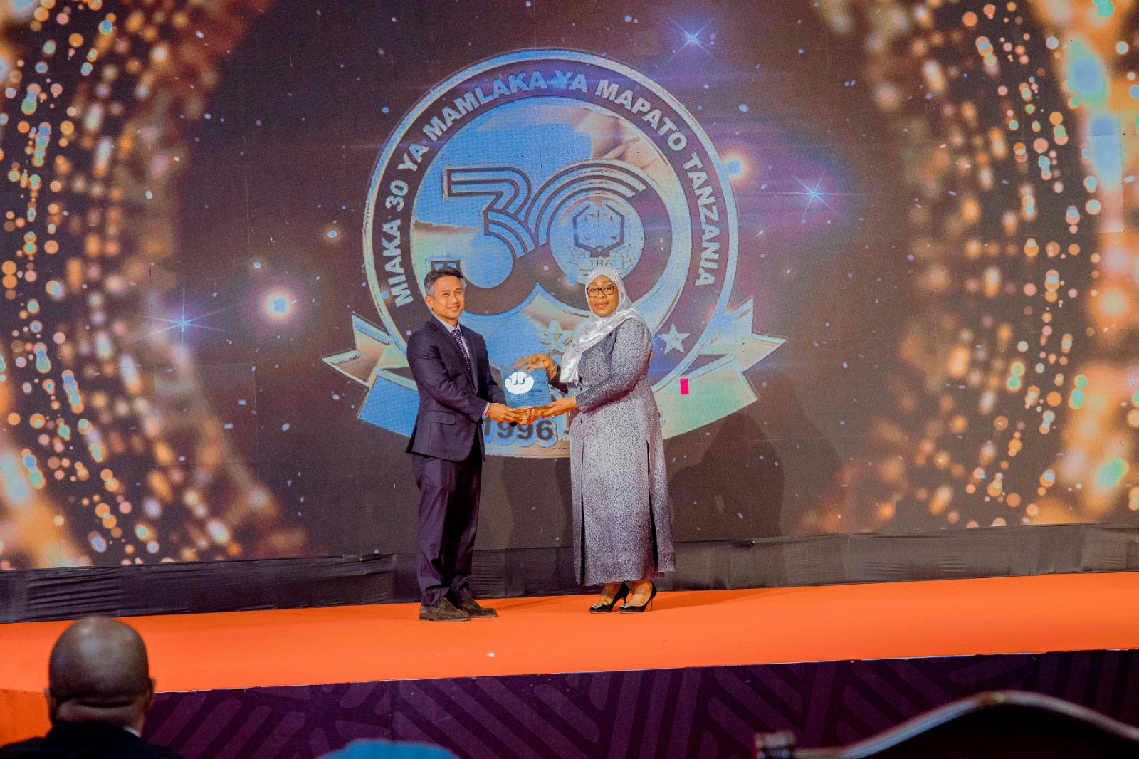 President Samia Suluhu Hassan presents an award for Overall Most Compliant Taxpayer and Outstanding Tax Contributor in Financial Year 2024/2025 to the Managing Director of Geita Gold Mining Limited, Ashraf Suryaningrat.